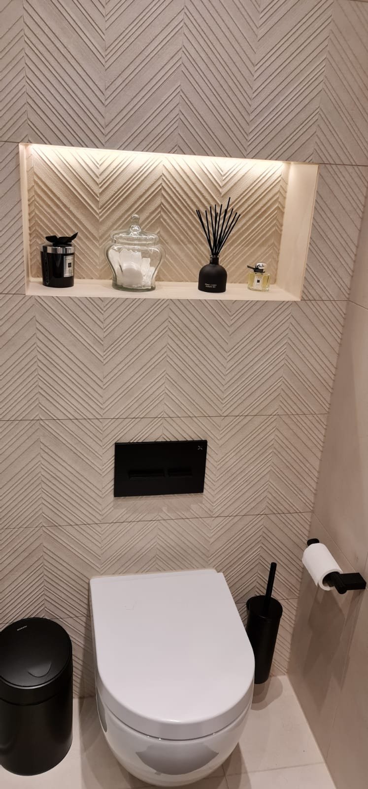 Guest WC with textured chevron tiling and lit niche